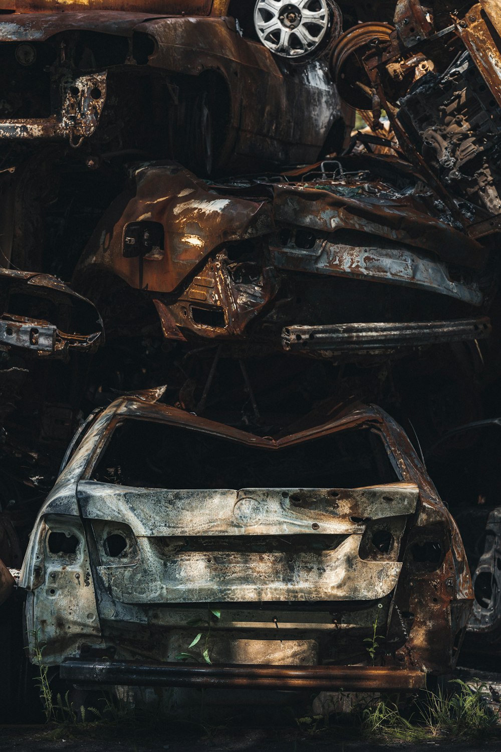 a rusted out car with a large dent in the front