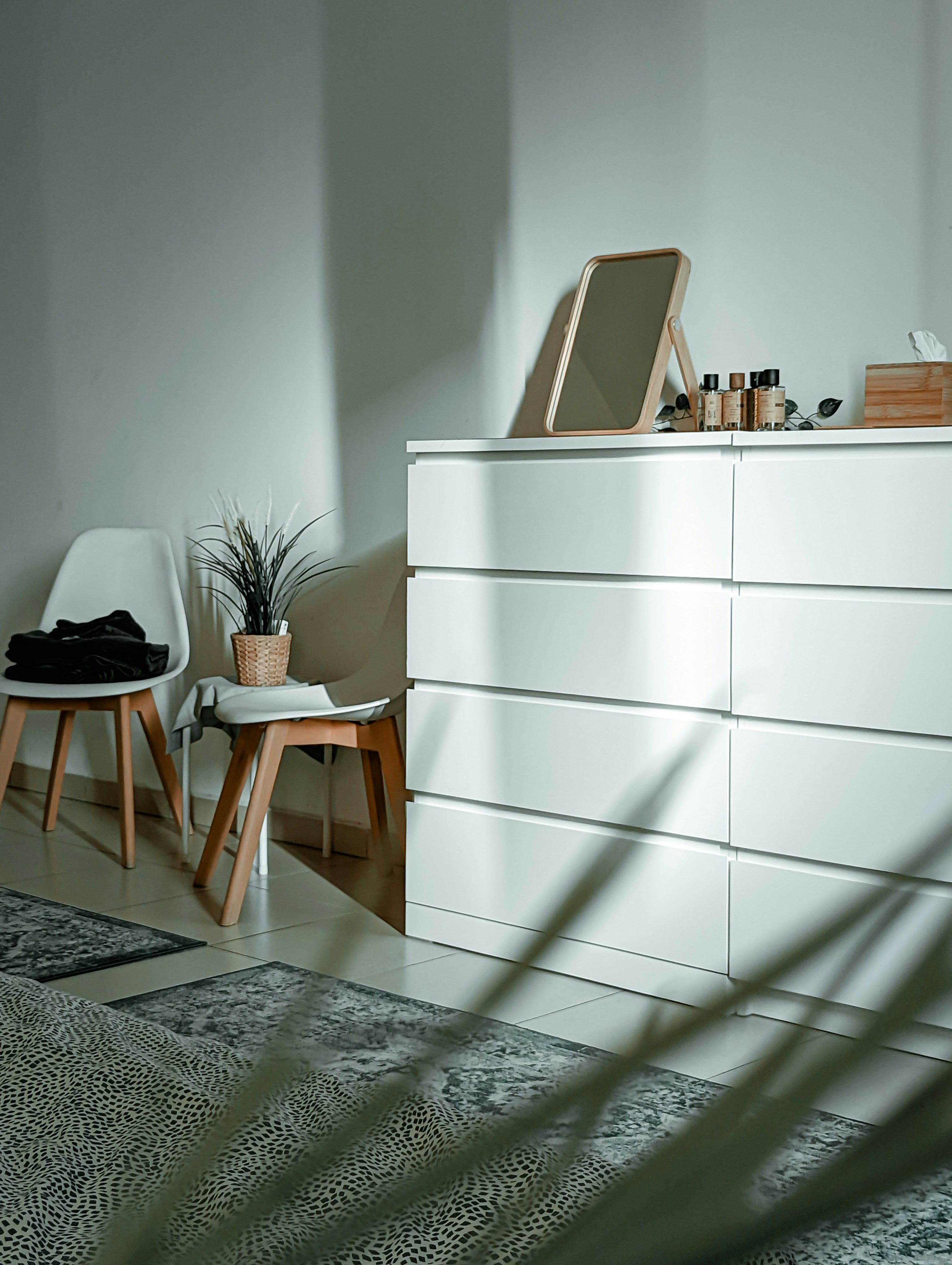 a white cabinet with a chair and a plant on top