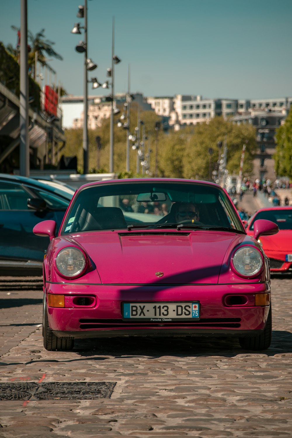 Una macchina rosa su una strada