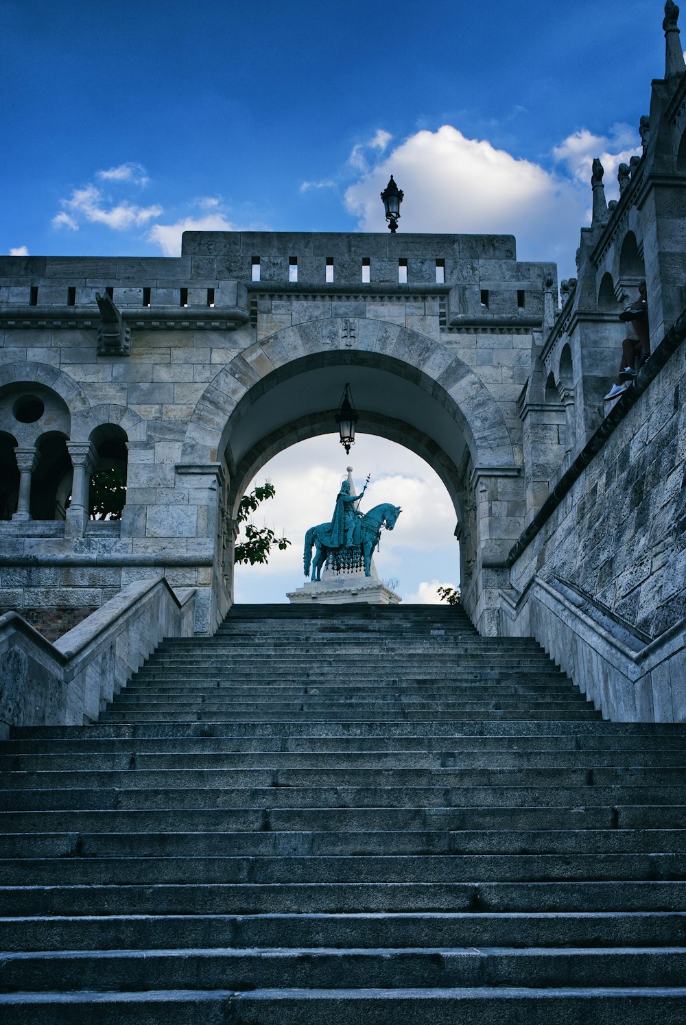 Un grande edificio in pietra con una statua in cima