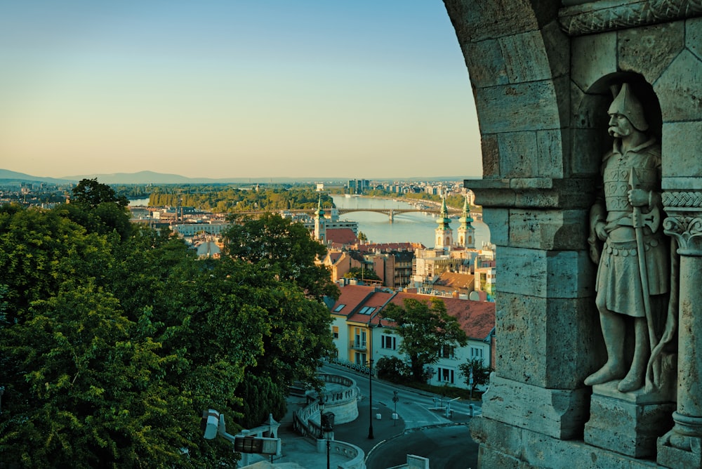 a statue of a person with a city in the background