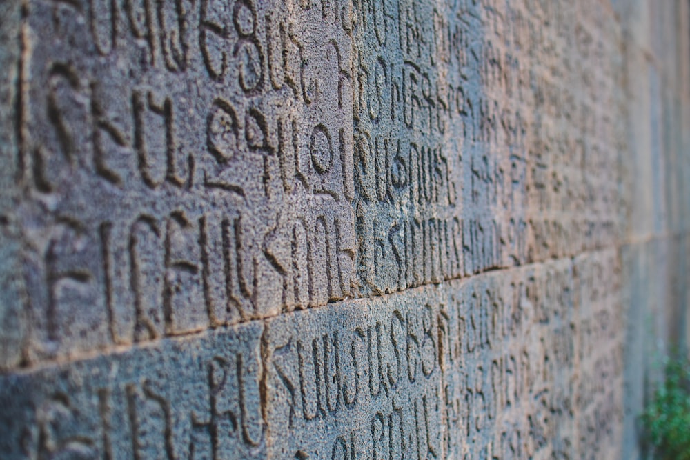 un mur de pierre avec des inscriptions dessus