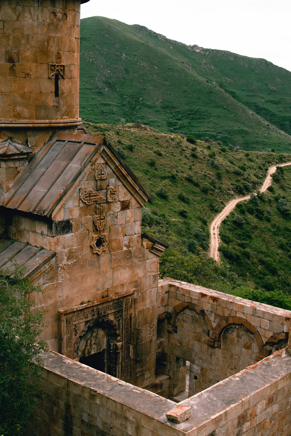 a stone building with a hill in the background