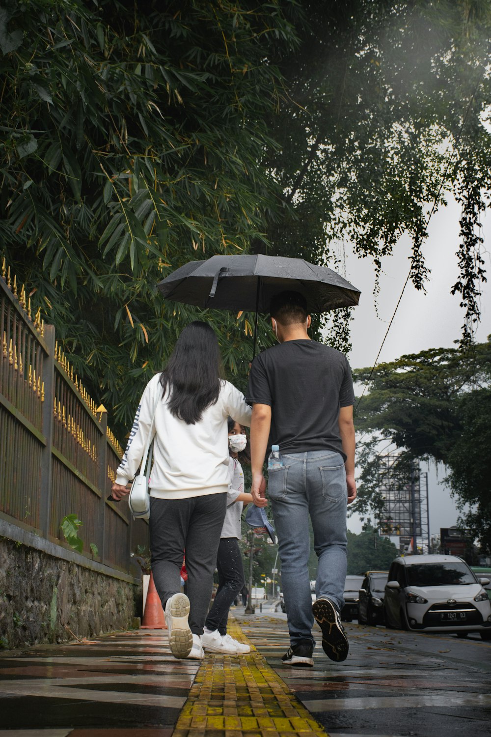 a man and a woman walking under an umbrella