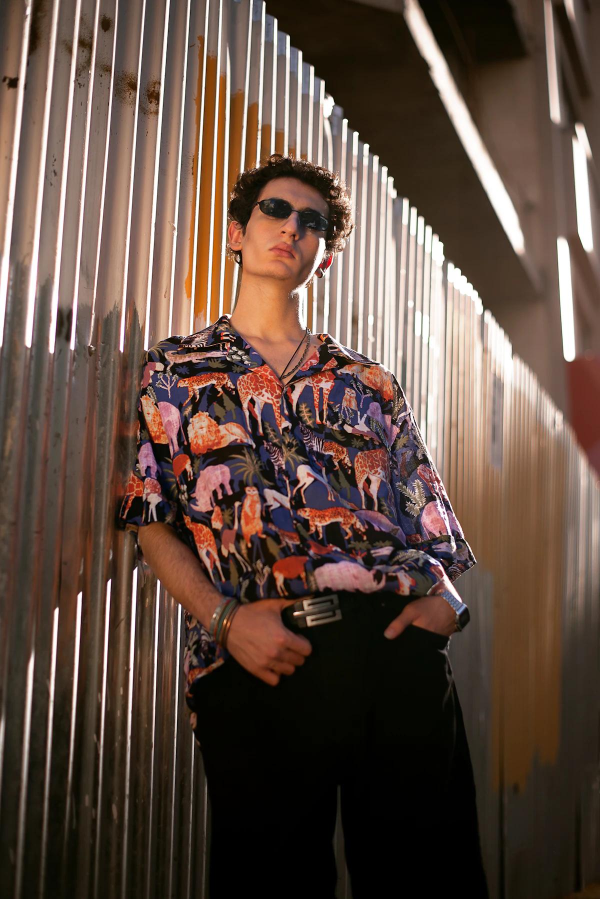 A loose camp-collar button-down shirt worn over relaxed black trousers