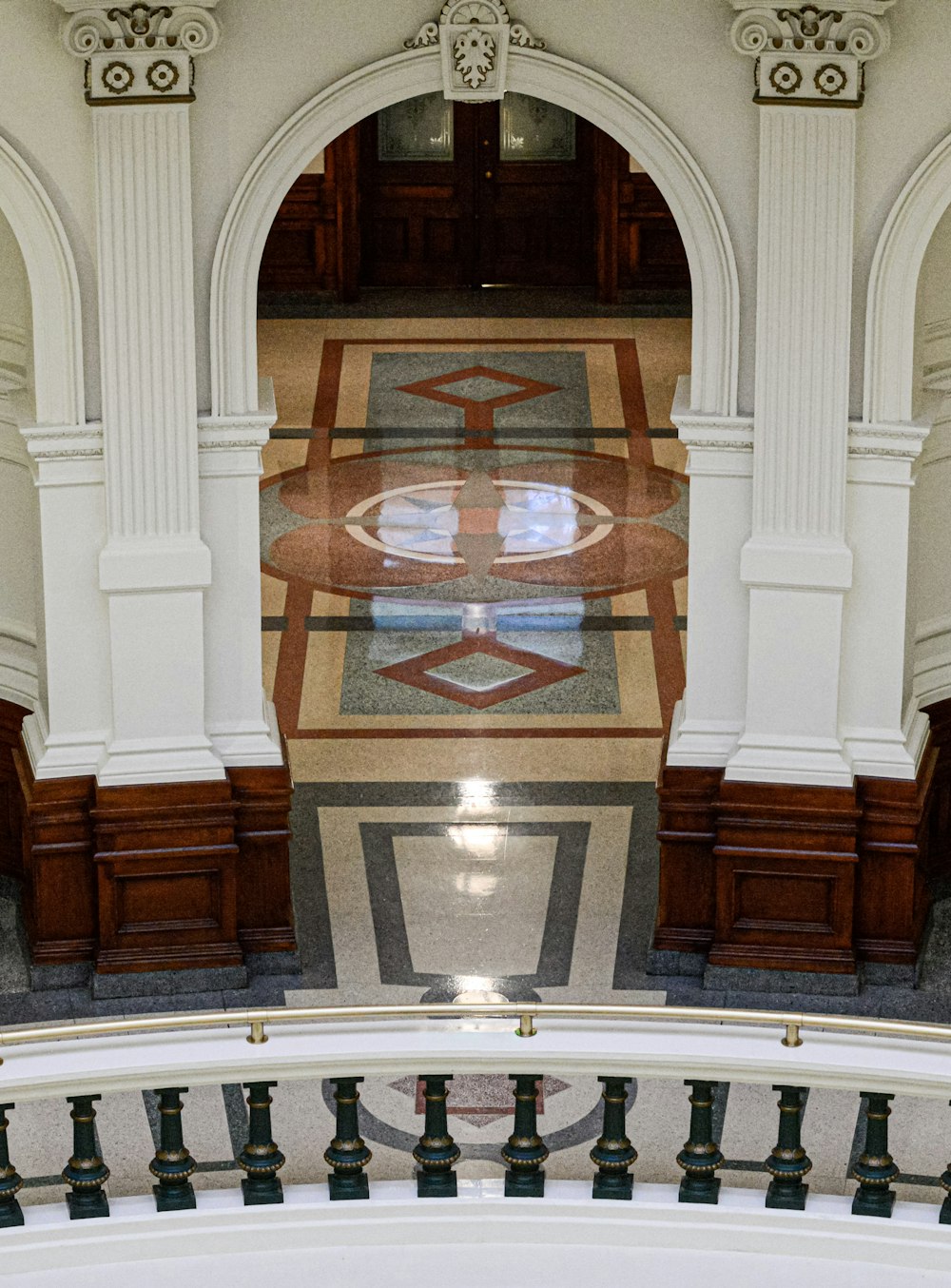 a large ornate room with a large rug and a large staircase