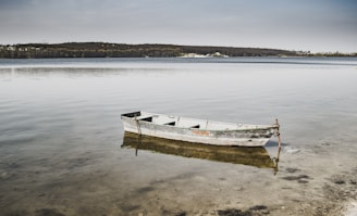 a boat sits in the middle of a lake