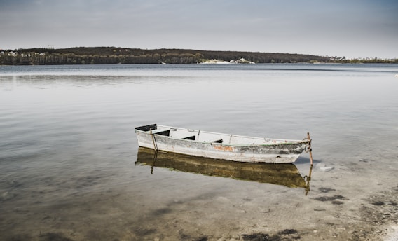 a boat sits in the middle of a lake