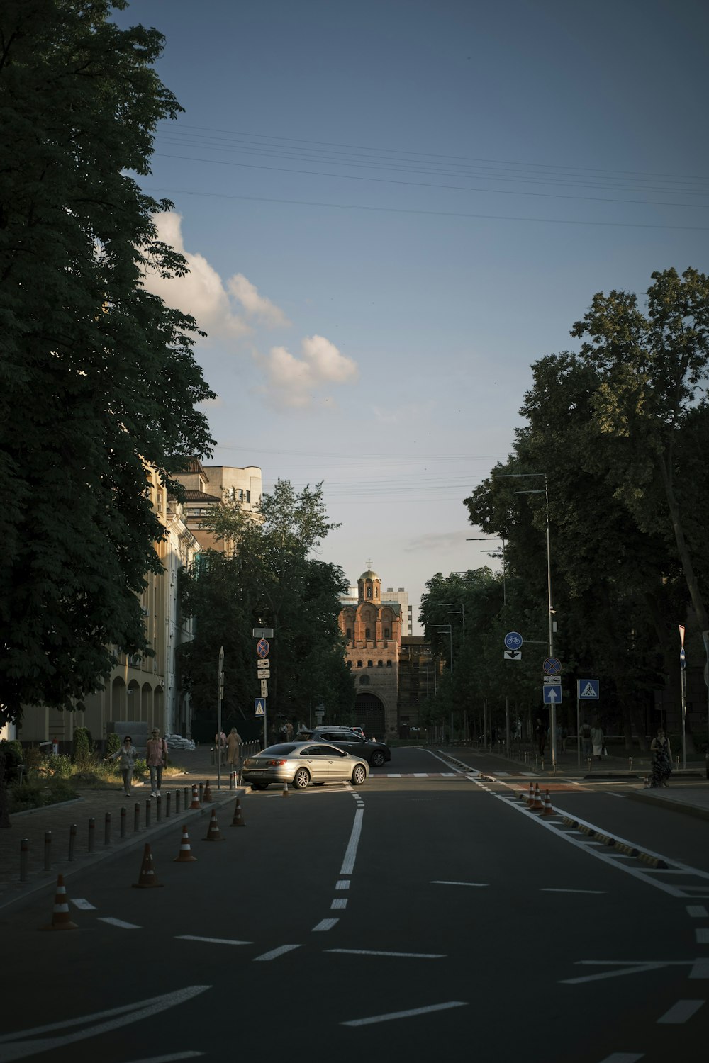 a street with cars and trees on the side