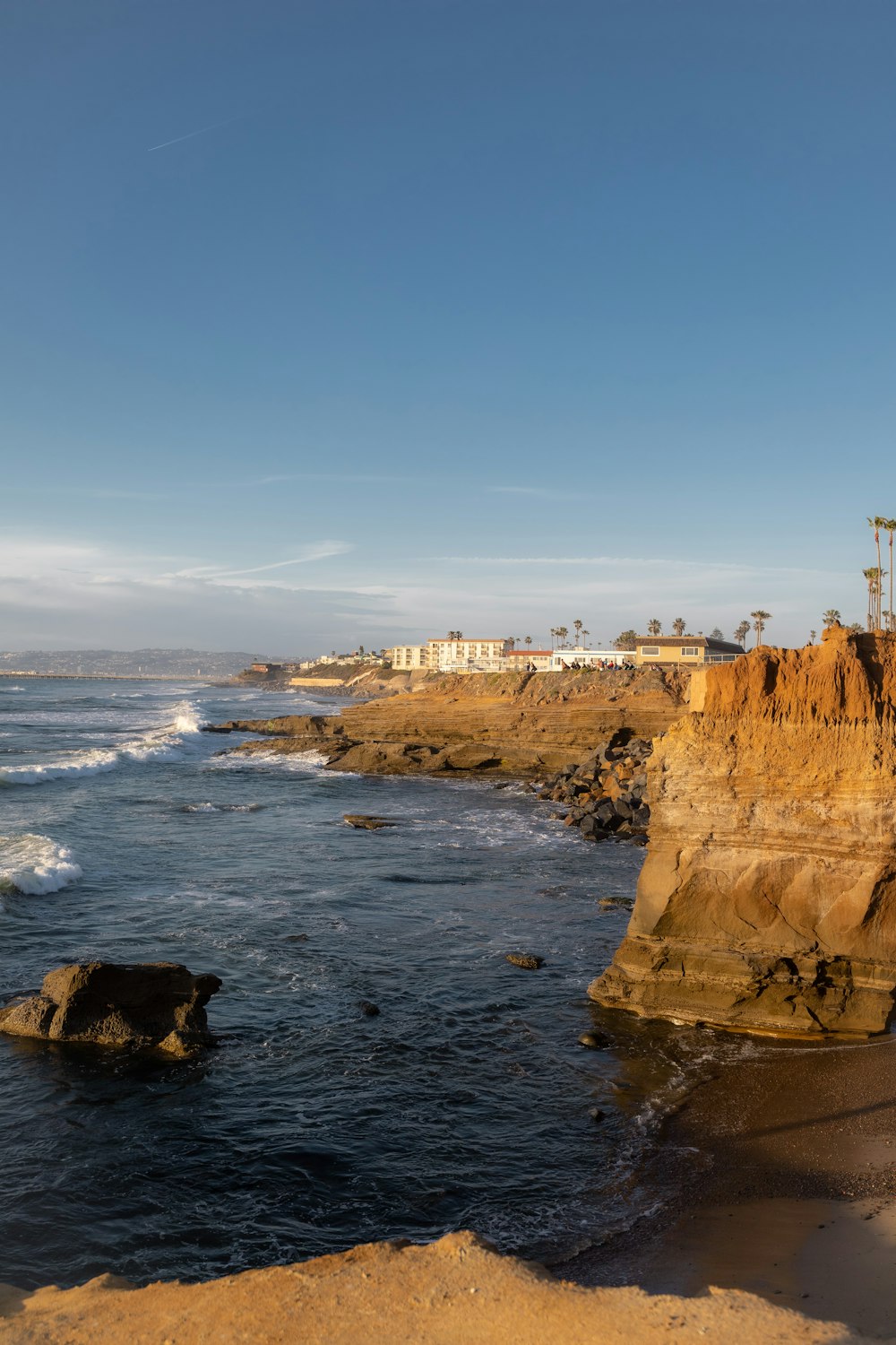 a rocky beach with a building on the shore