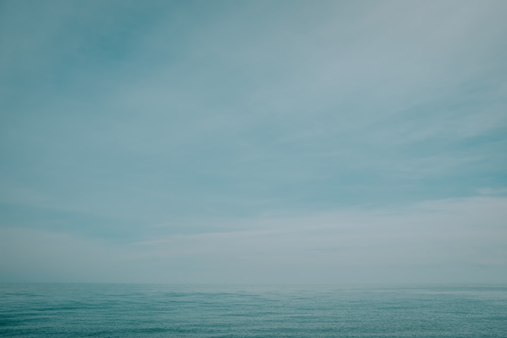 a body of water with a cloudy sky above it