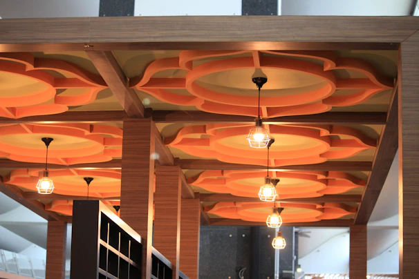 Decorative ceiling design featuring geometric patterns and warm orange accent lights.