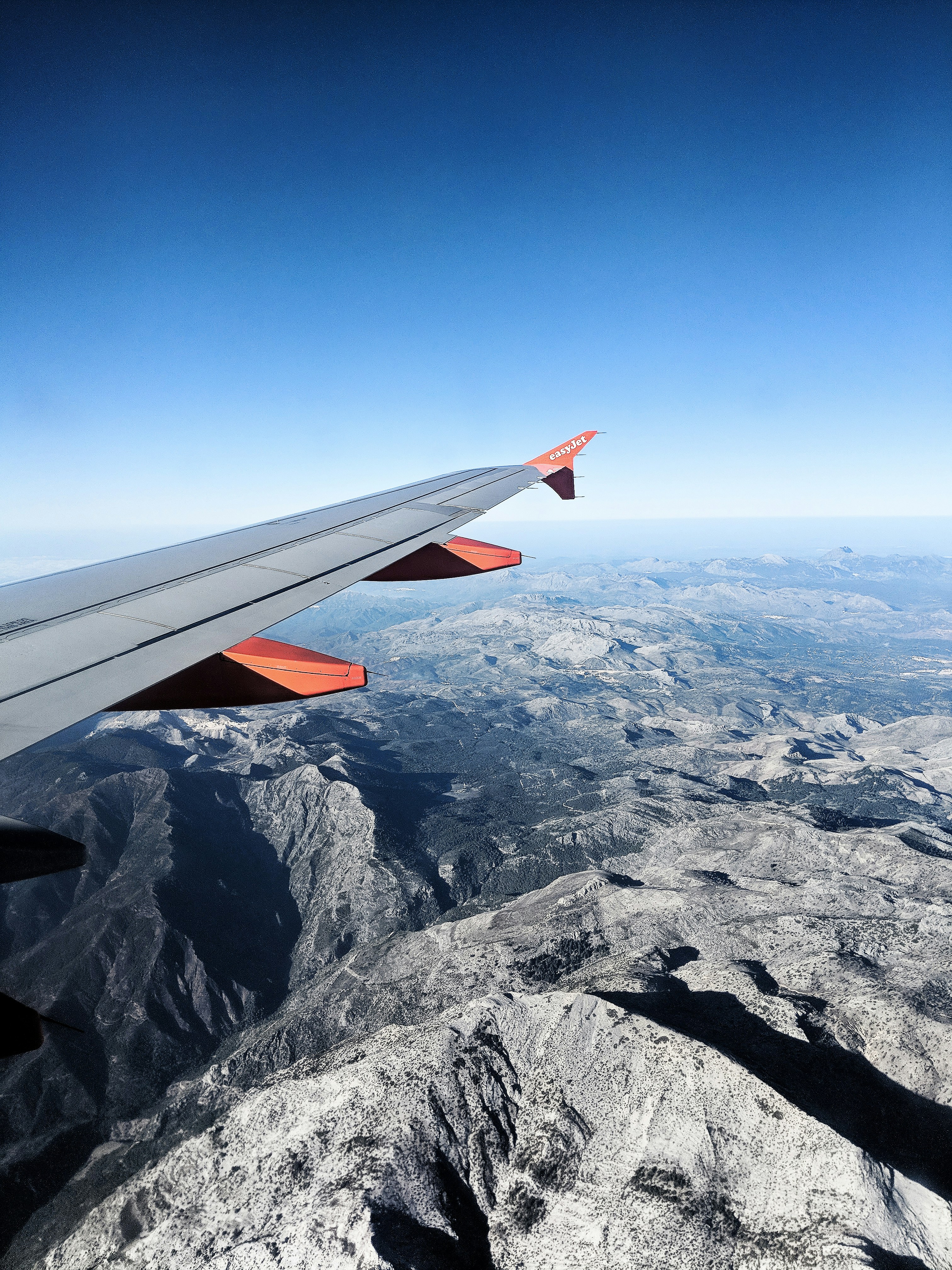 an airplane flying over snowy mountains