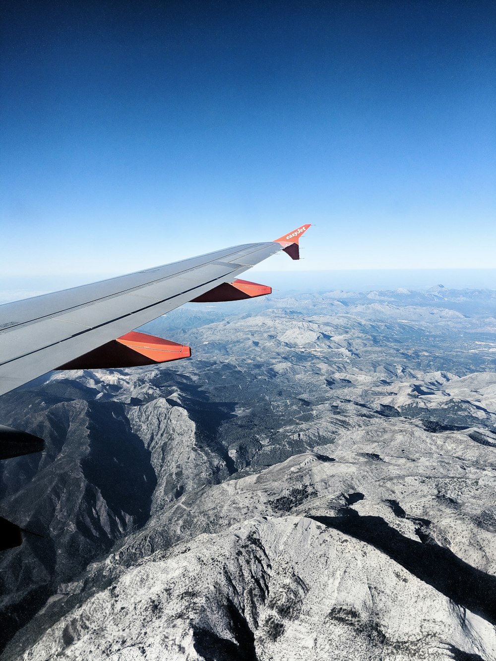 an airplane flying over snowy mountains