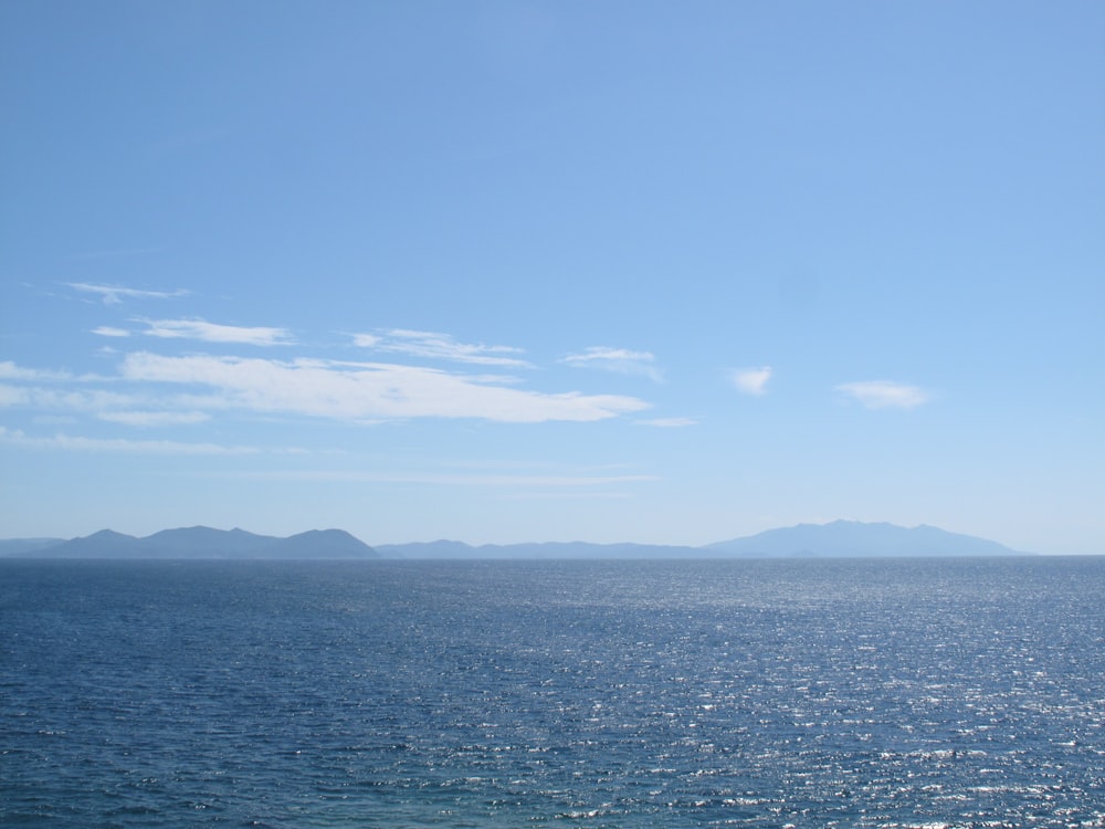 a body of water with mountains in the background