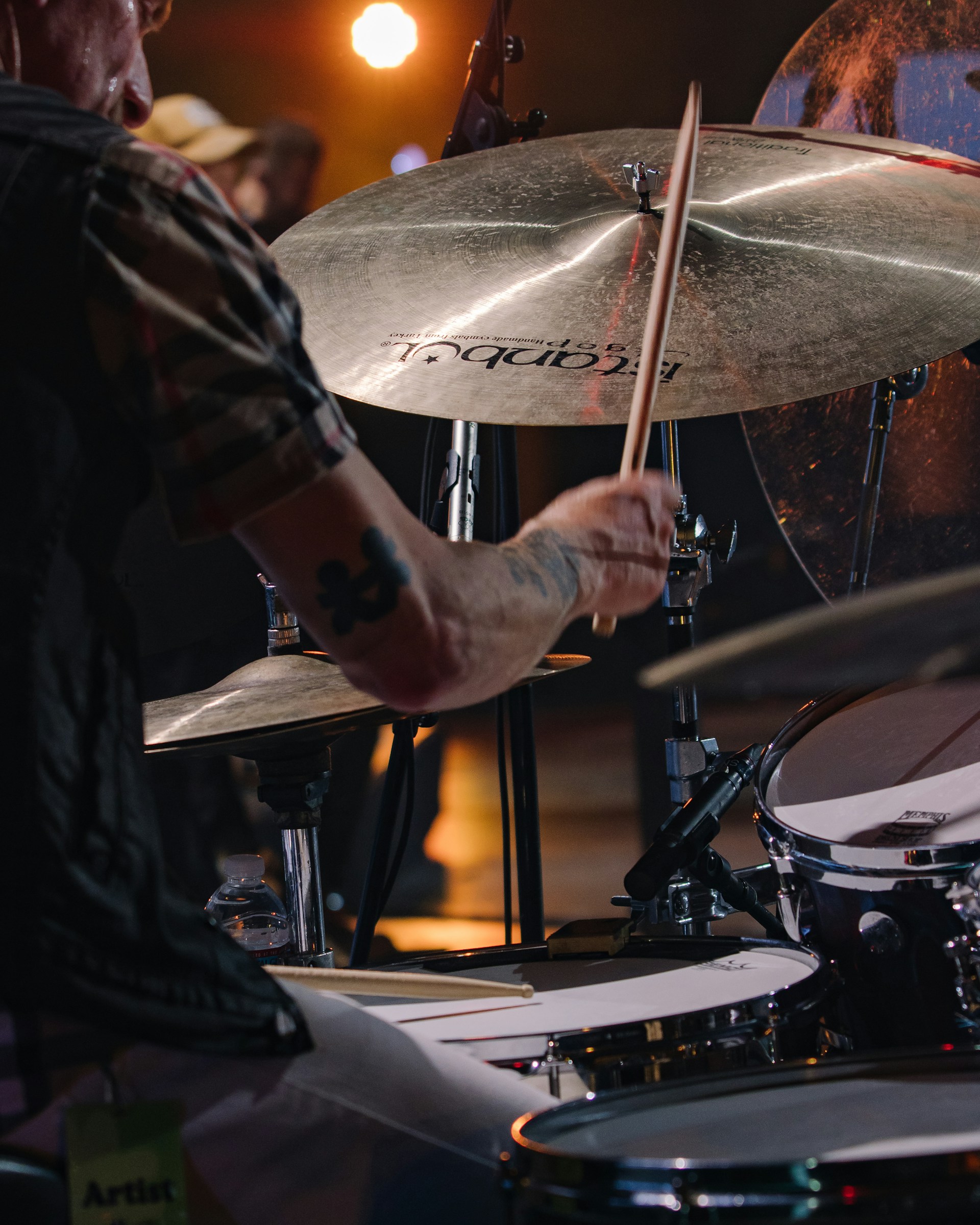 Close-up shot of Shaan Frenƶy's hands gripping drumsticks mid-beat, showcasing intense focus and energy.