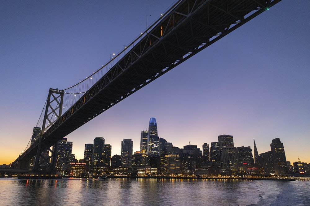 a bridge over a body of water with a city in the background