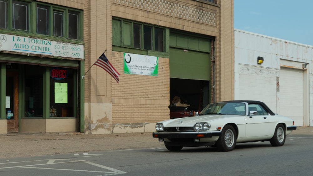 a car parked in front of a building with a flag on top
