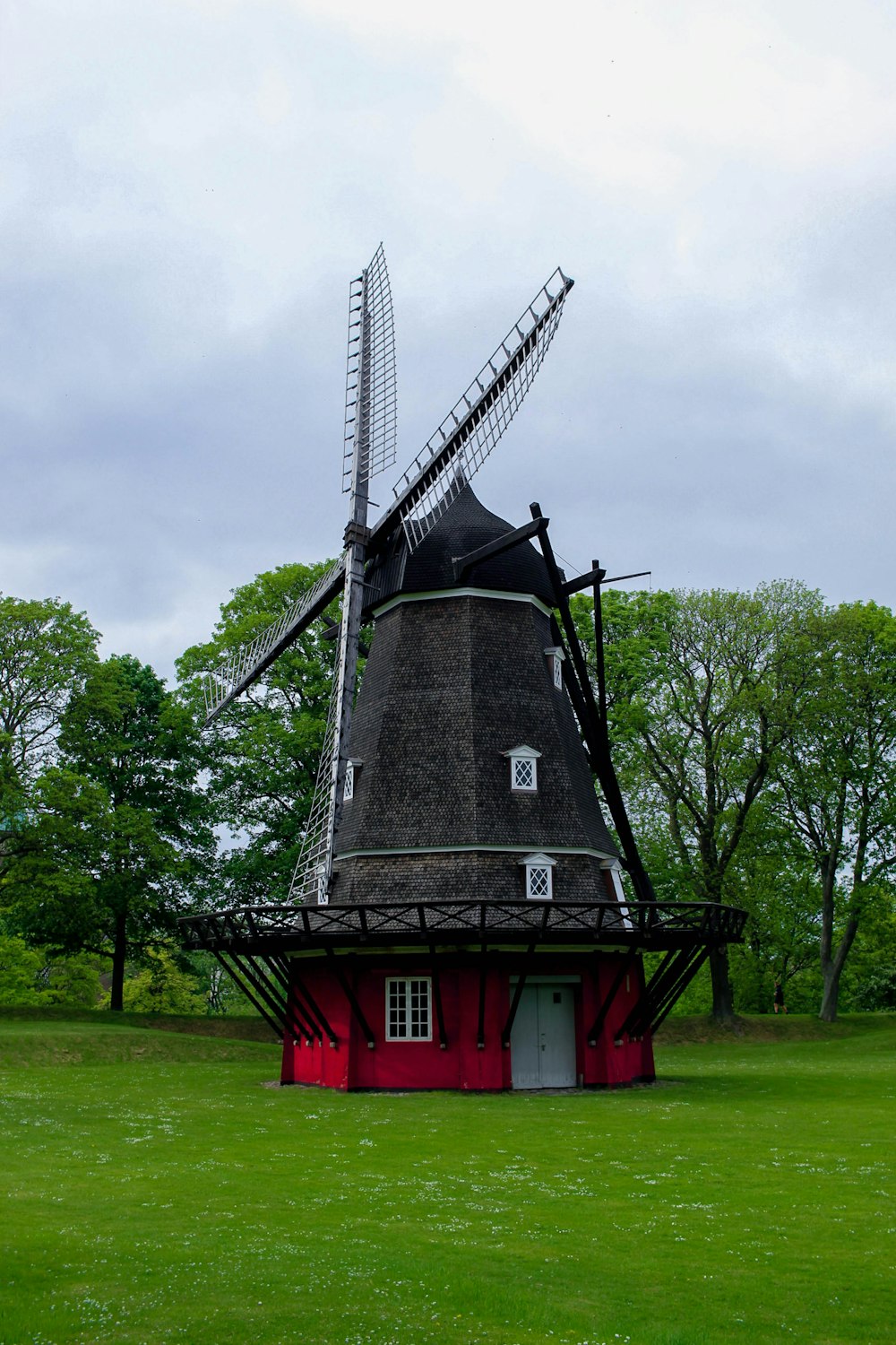 a windmill in a field with Eastham Windmill in the background