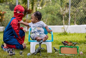 a boy and a girl playing with a bird in a yard