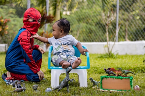a boy and a girl playing with a bird in a yard