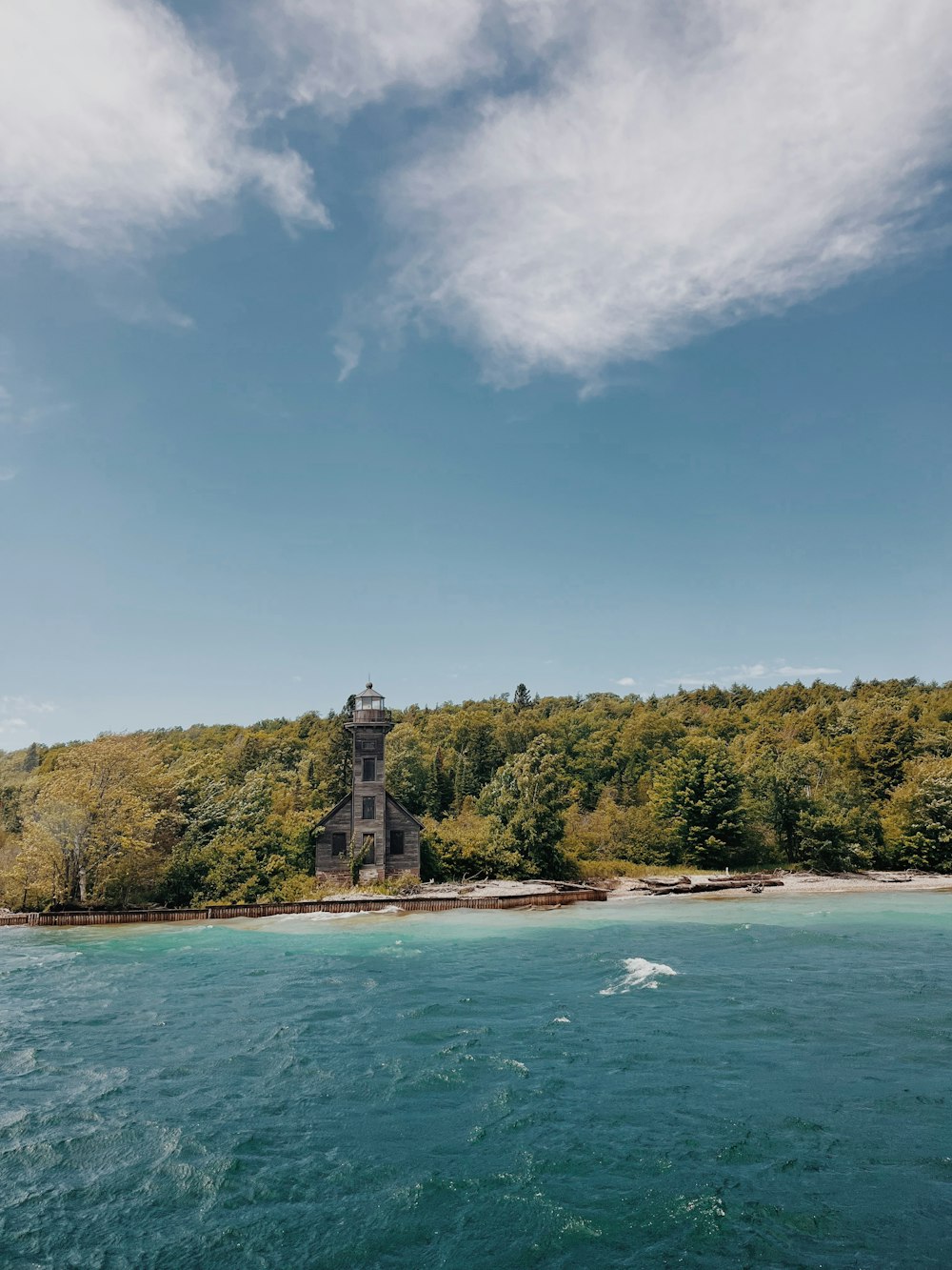 a lighthouse on a hill by the water