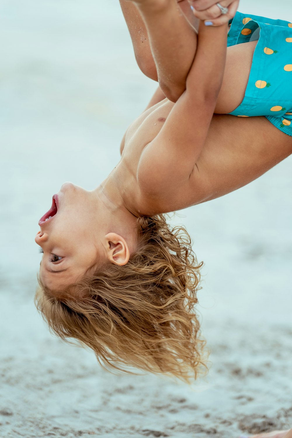 a woman lying on her back on the beach