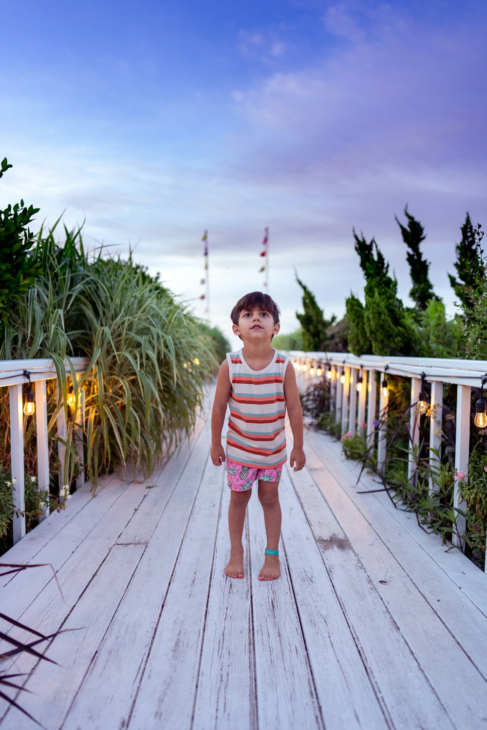 a child standing on a wooden bridge