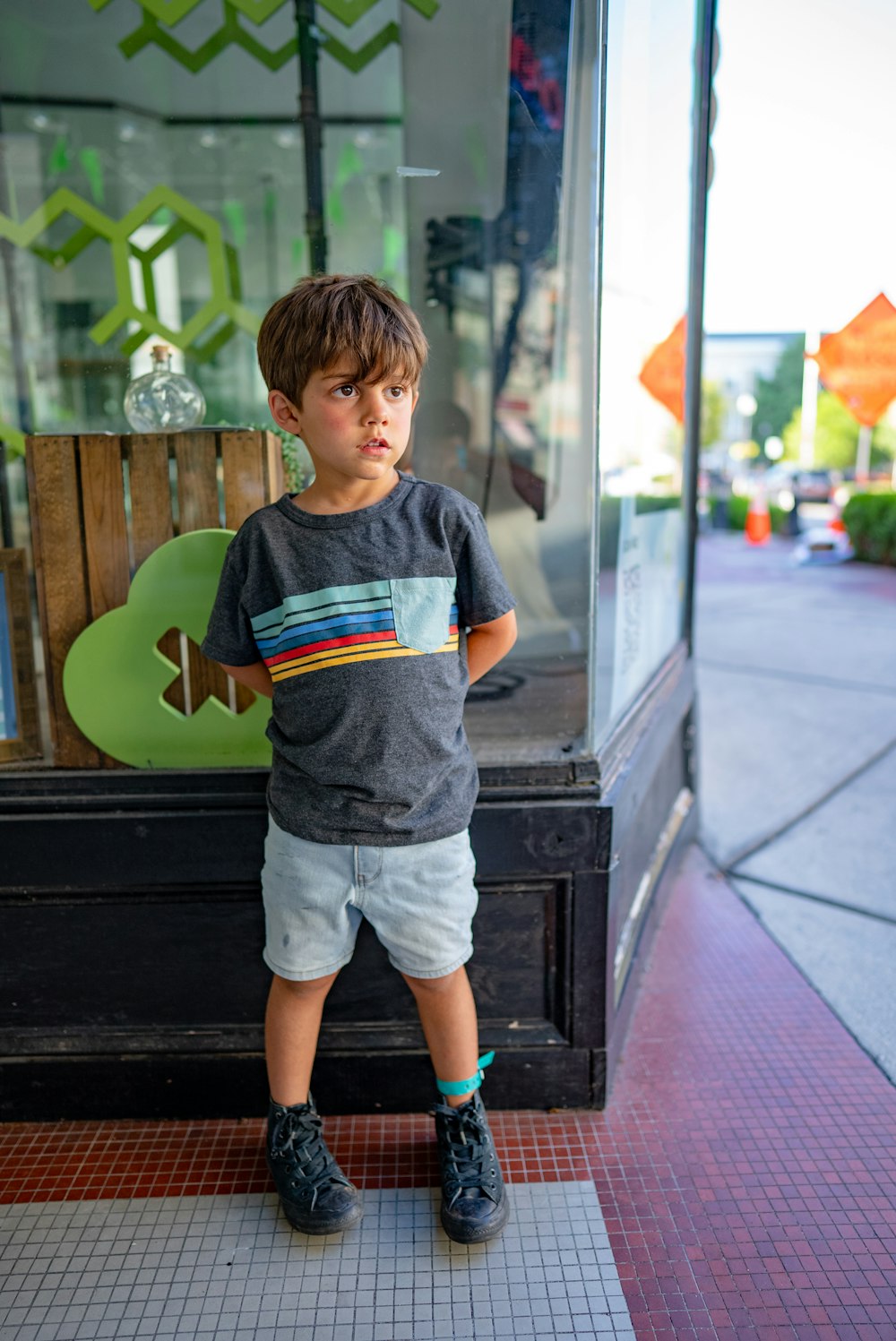 a boy standing in front of a glass door