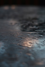 Close-up of a smooth quartz surface reflecting water light in a luxury spa setting.