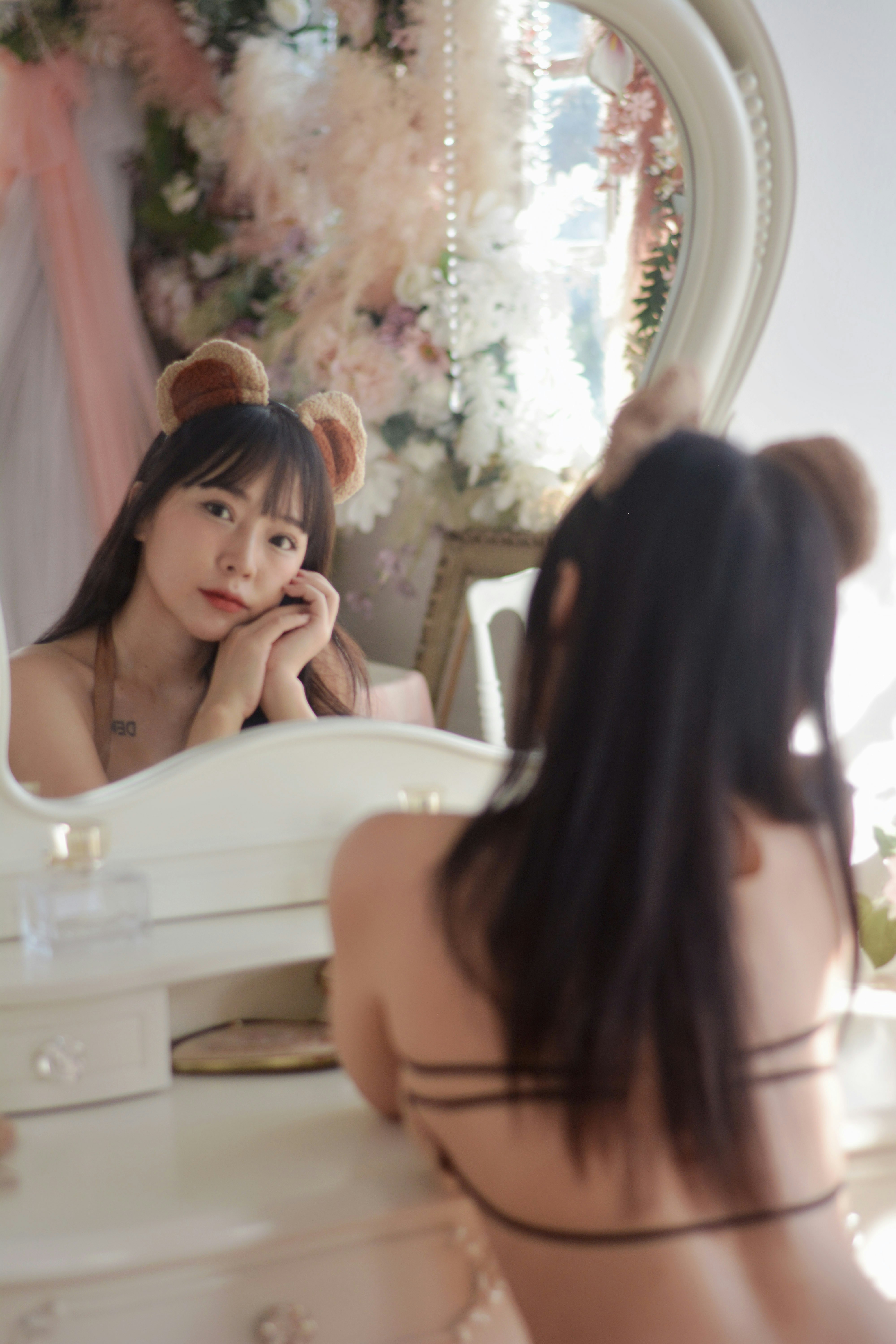 a woman in a garment in front of a mirror