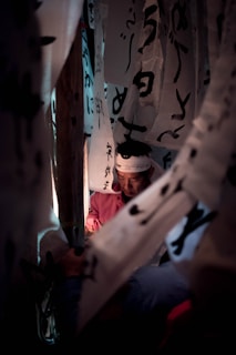A vibrant classroom scene with students eagerly practicing Japanese calligraphy under warm lighting.