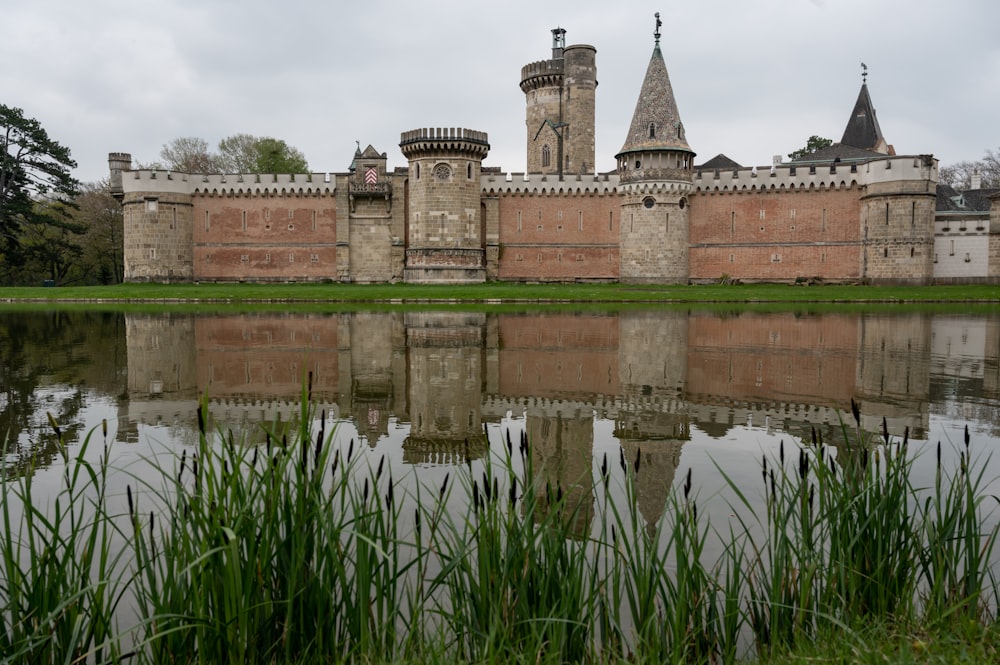 a building with towers and a pond