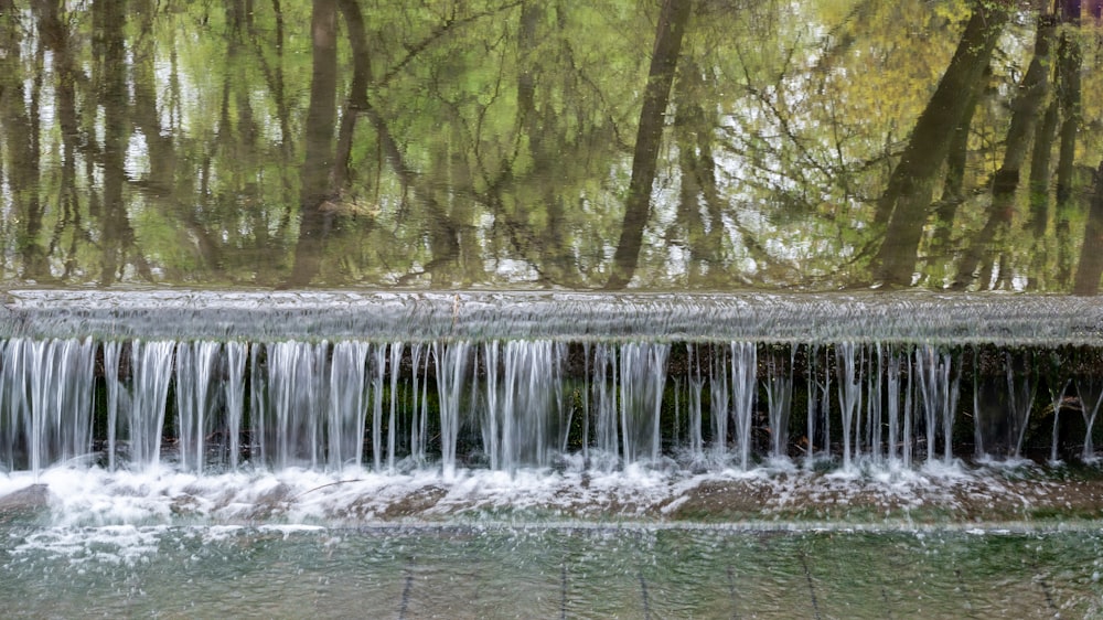 a waterfall with a log in the water