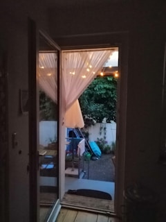 An outdoor patio with a door fitted with a pleated insect screen.