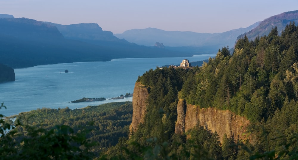 a cliff with a building on it by a body of water