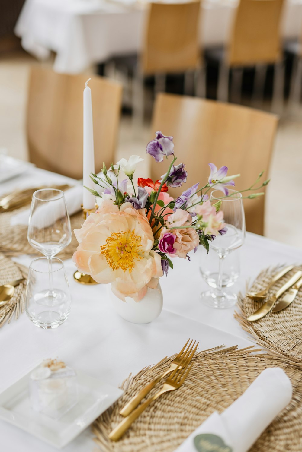 a table with a vase of flowers and glasses