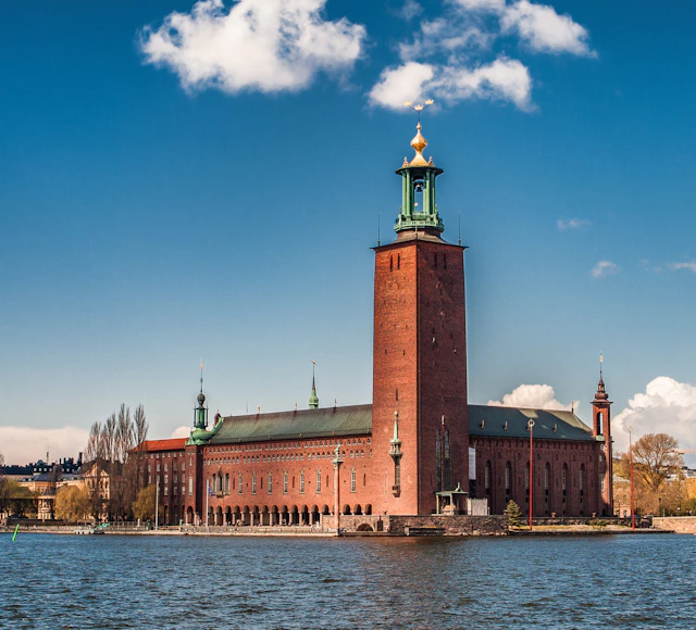 Stockholm City Hall with its red-brick tower and golden crown beside the water