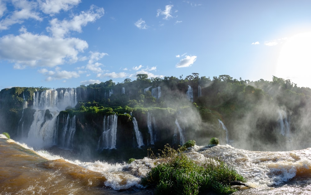 a waterfall with a city in the background