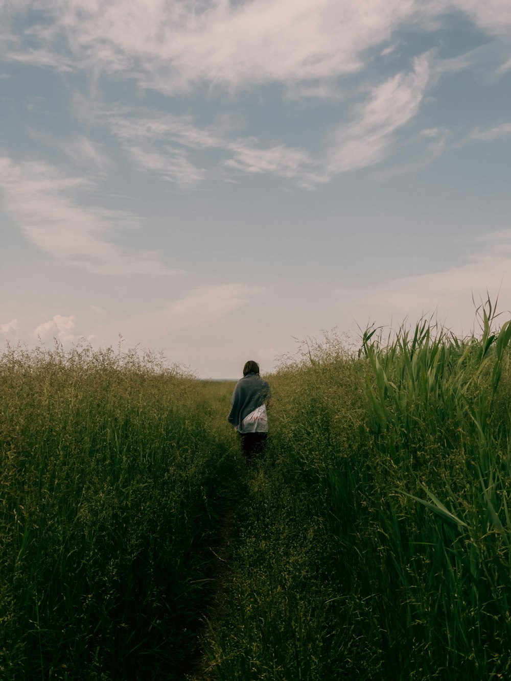 a man and a child walking through tall grass