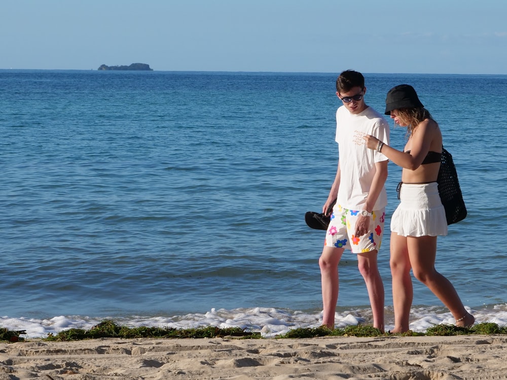 Un hombre y una mujer caminando por una playa