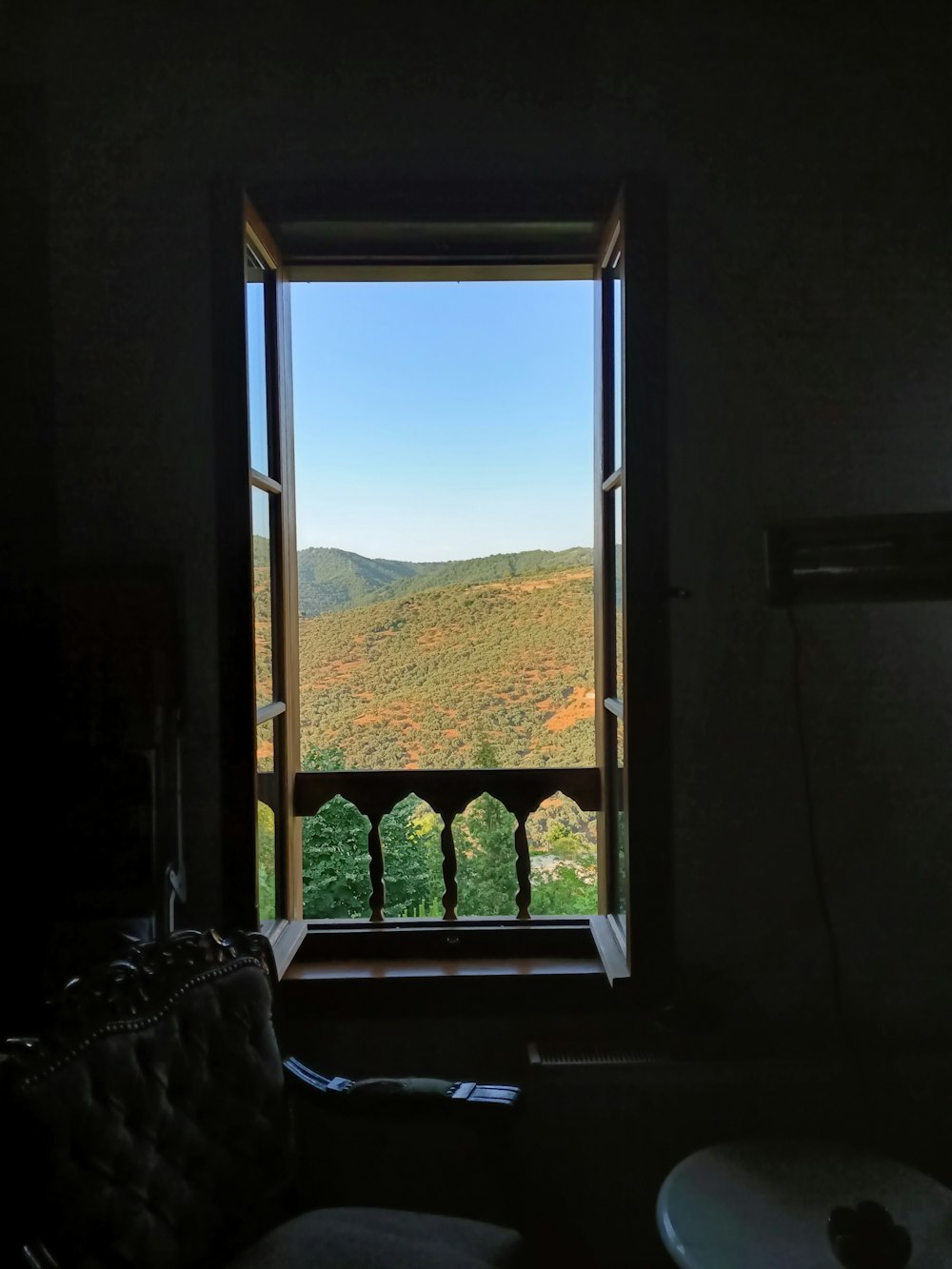 a window with a view of a mountain and trees