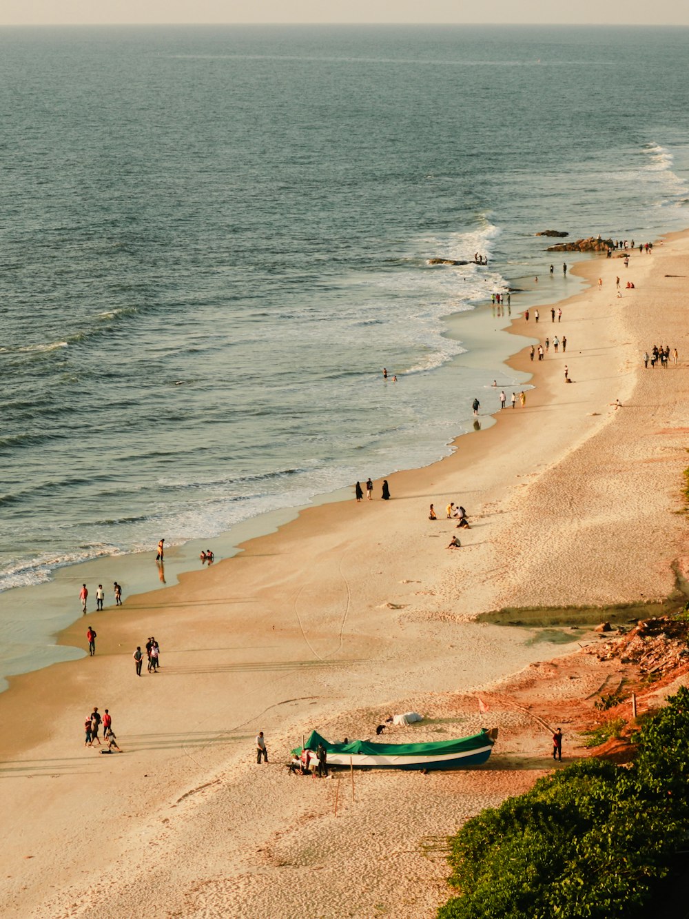 a beach with people and a boat