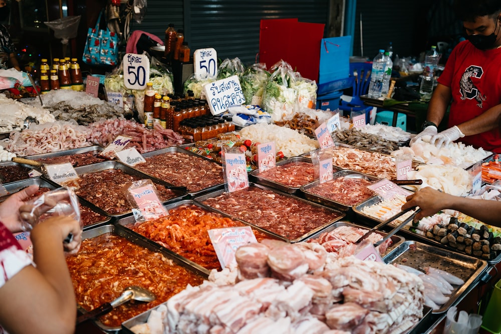 a group of people standing next to a table full of fish