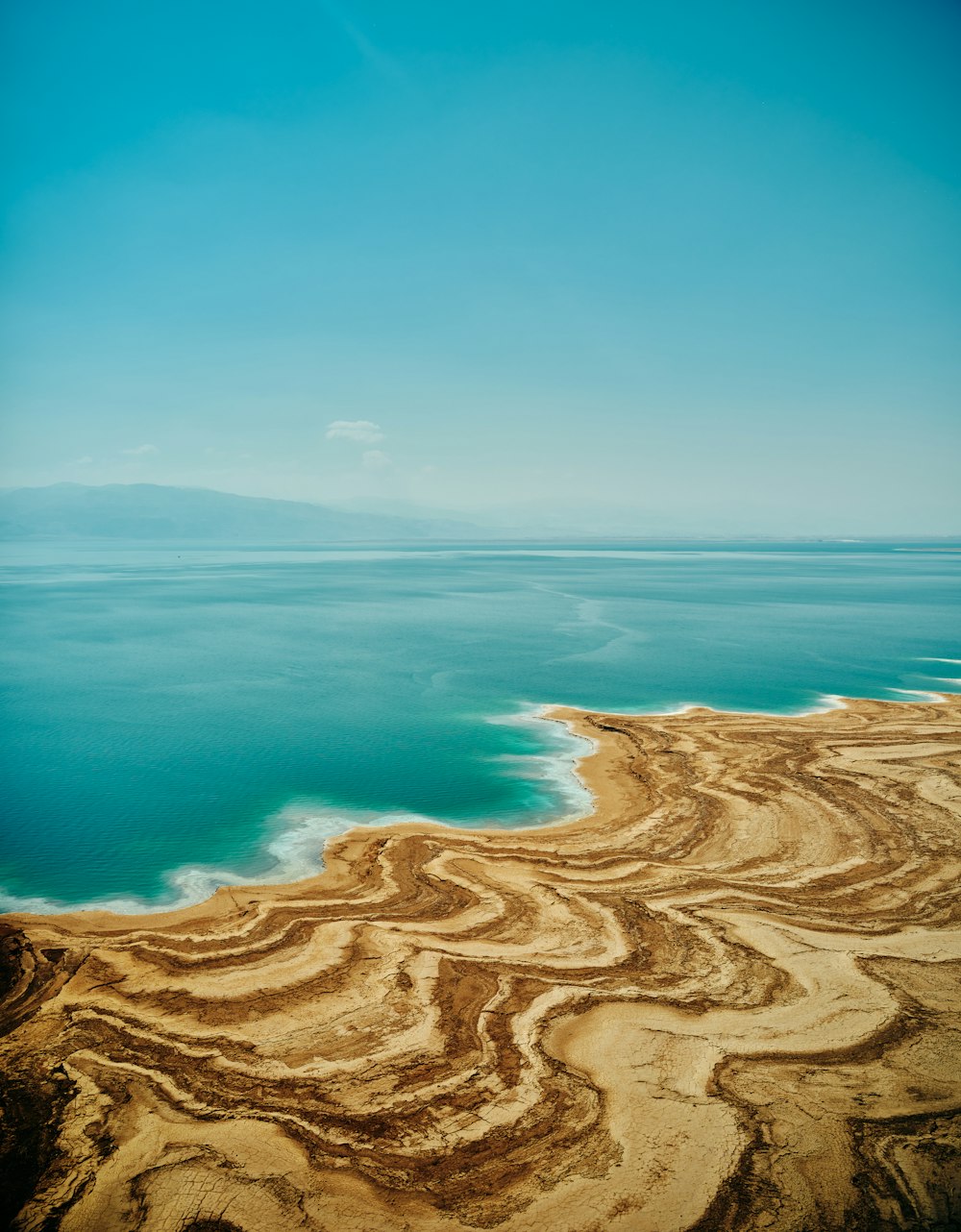 a sandy beach with a body of water in the background