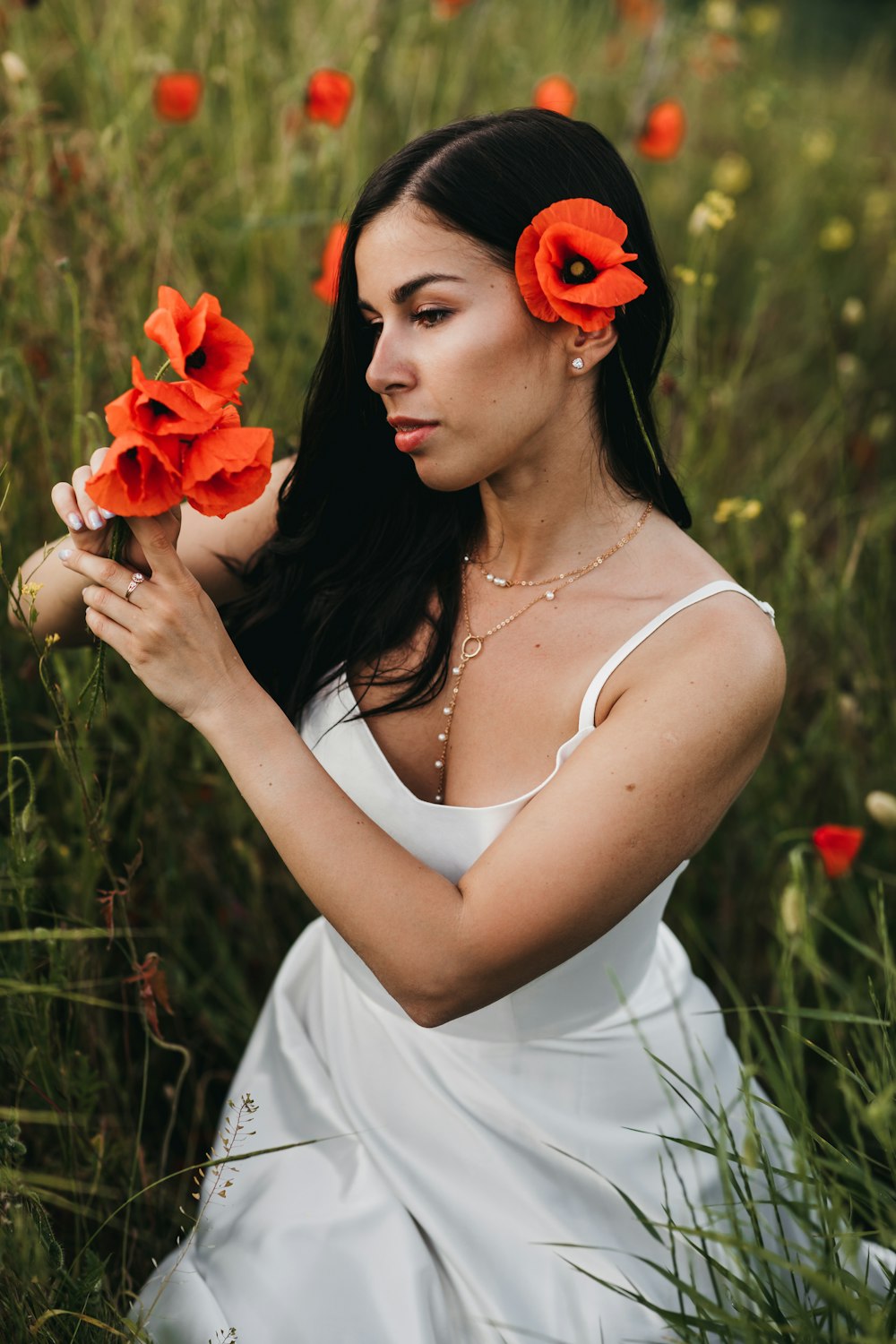 Una mujer con un vestido blanco sosteniendo flores