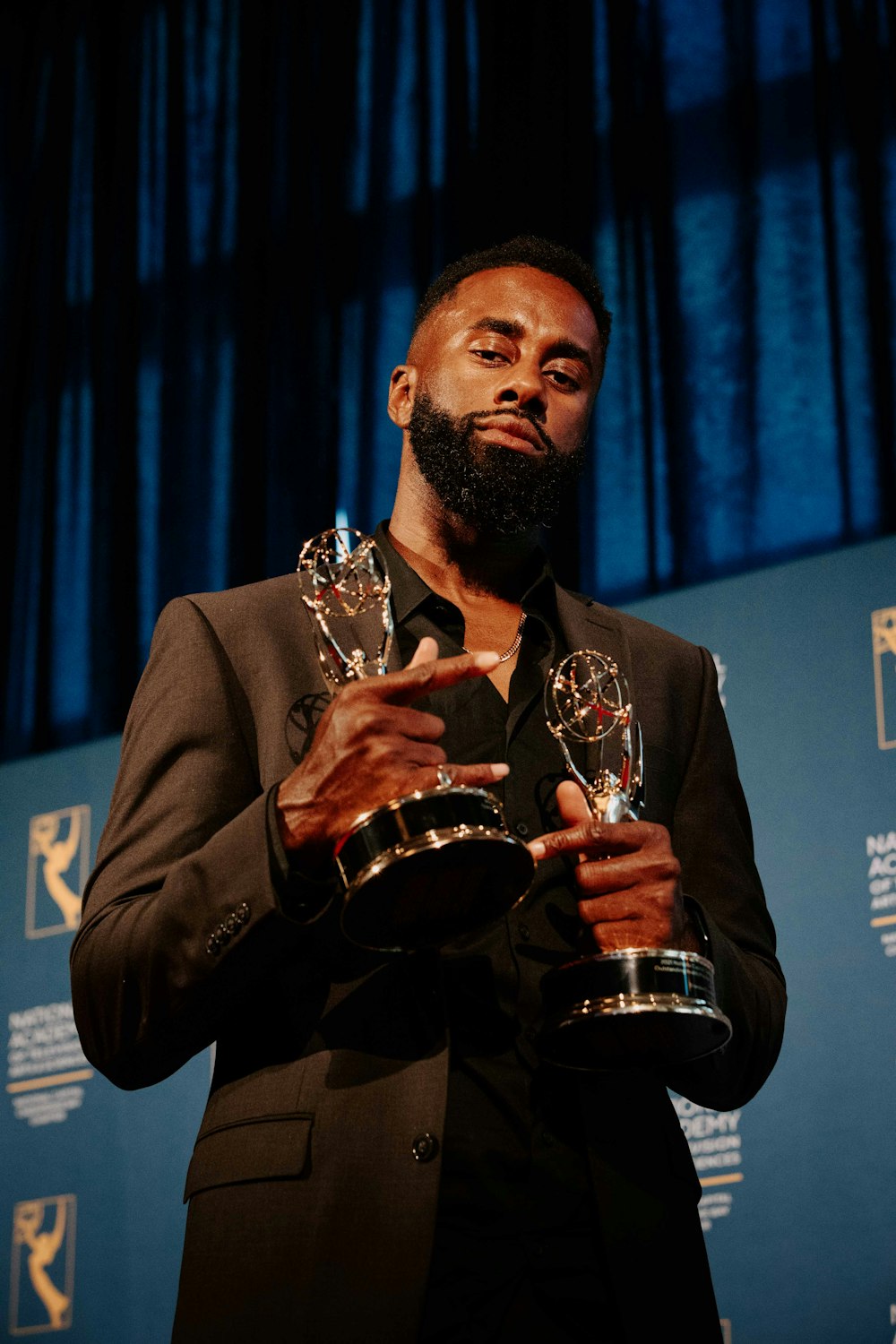 a man holding trophies