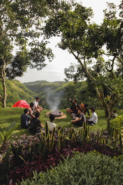a group of people sitting on a bench in a park