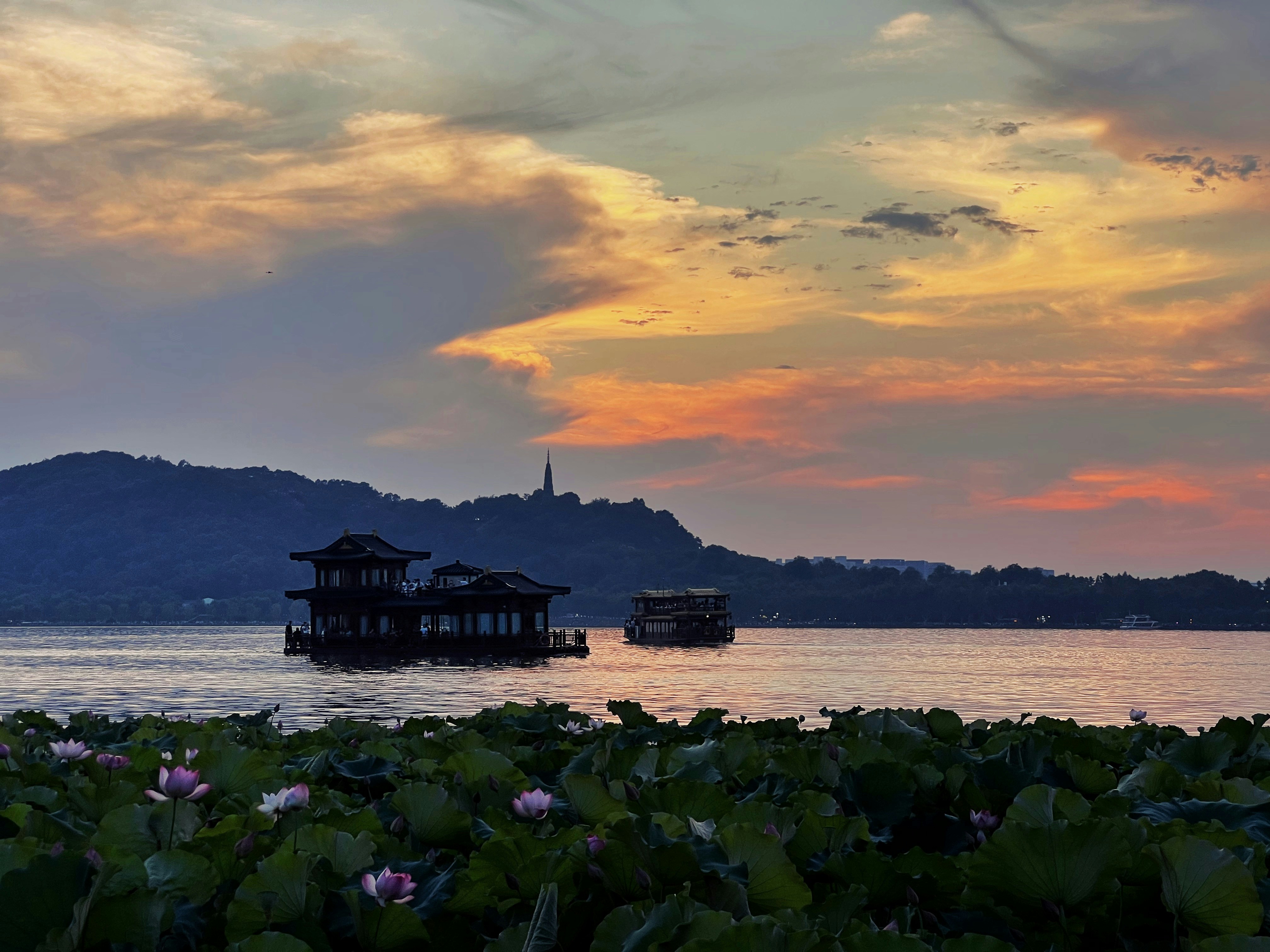 Romantic sunset view over Dal Lake with flower-decorated shikara boat