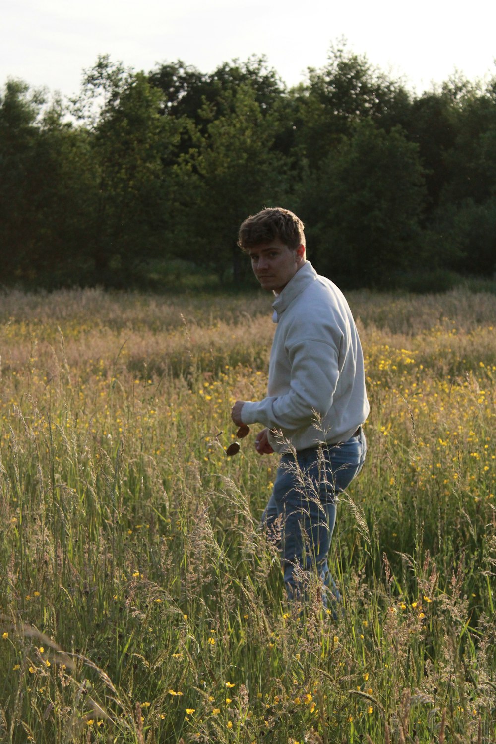 a man walking through a field of grass